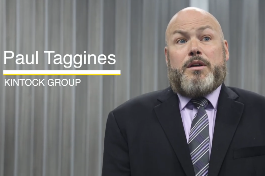 A man in a suit and tie stands in front of a gray background. On screen text reads: Paul Taggines, Kintock Group—an organization recognized for its impactful reentry programs.